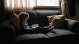 Bé gái nhỏ ngồi đọc một mình